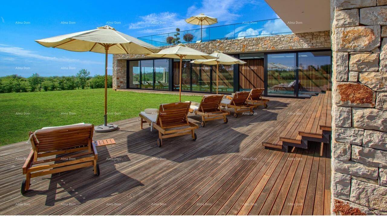 Weitläufige Holzterrasse mit Sonnenschirmen und Liegestühlen vor einer modernen Steinfassade mit großen Fenstern.