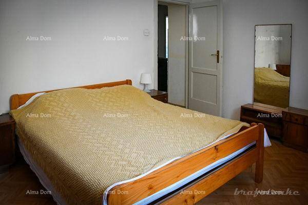 Schlafzimmer mit Doppelbett aus Holz, Nachttischen und einem großen Spiegel.