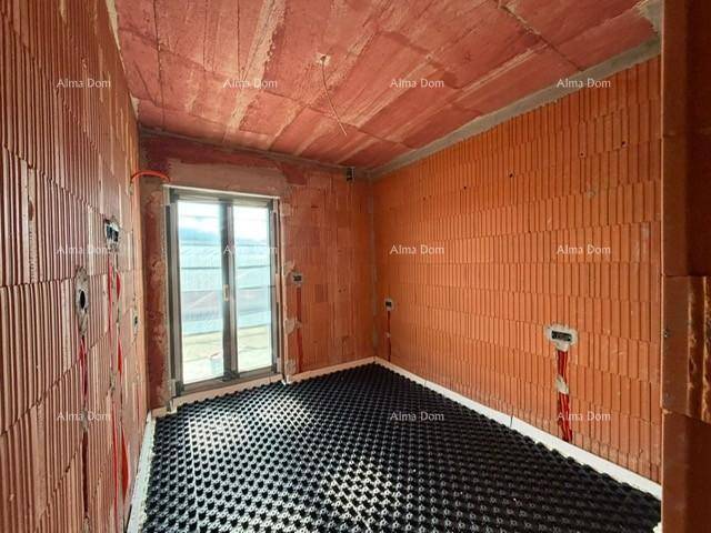 Unfertiges Schlafzimmer mit Ziegelwänden, Fußbodenheizungsvorbereitung und Balkonzugang.