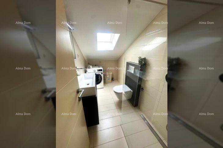 Modernes Badezimmer mit Dusche, WC, Waschmaschine und Dachfenster.
