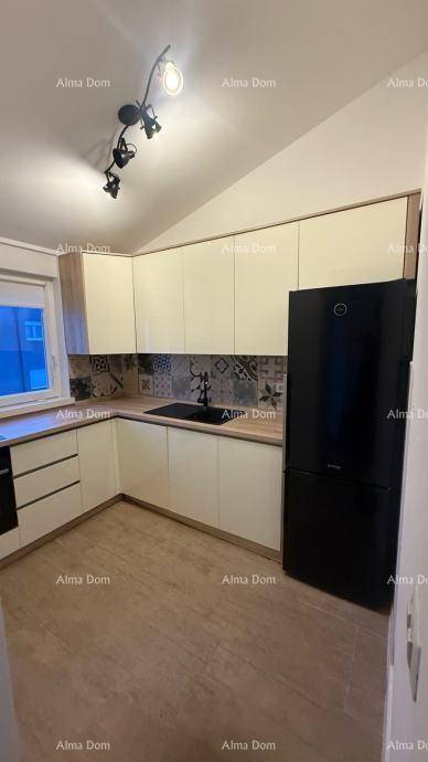 Moderne Küche mit hellen Schränken, Holzarbeitsplatte und schwarzem Kühlschrank.