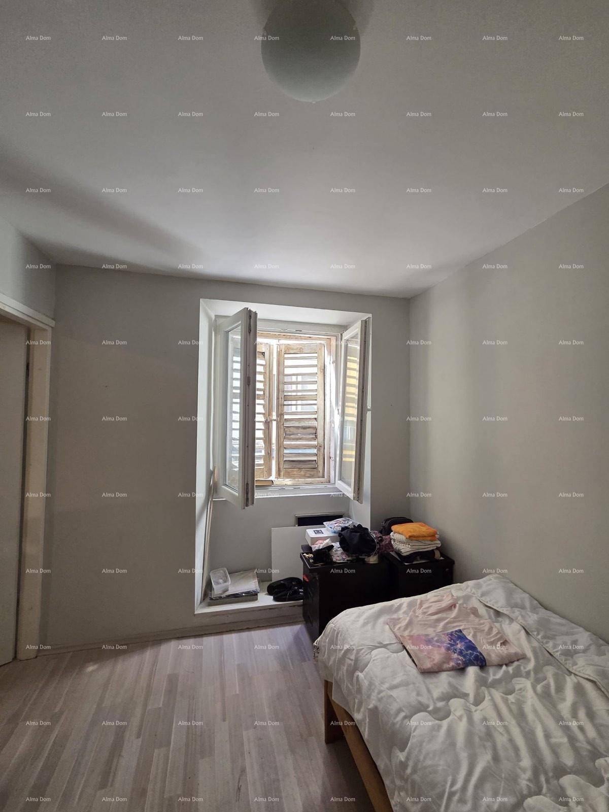 Helles Schlafzimmer mit Laminatboden, einem Bett und einem Fenster mit Holzläden.