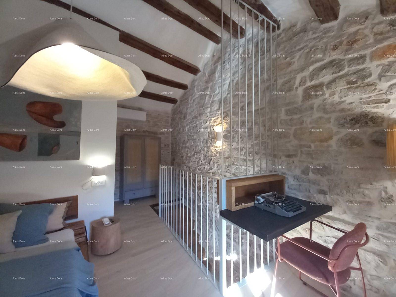 Schlafzimmer im Obergeschoss mit offener Galerie, Steinwänden und Holzbalkendecke.
