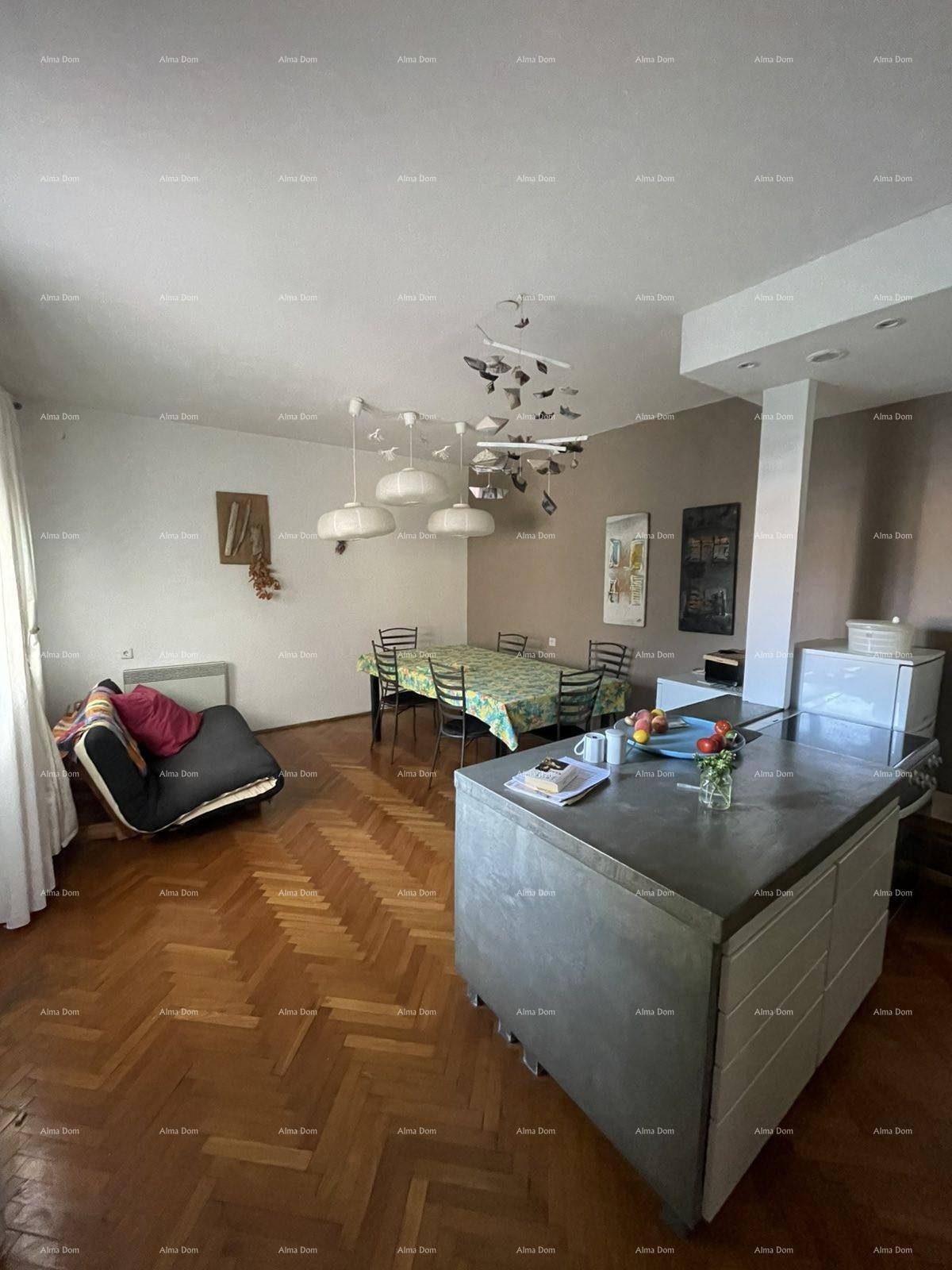 Offener Wohn- und Essbereich mit Holzboden, Esstisch und Kücheninsel im Hintergrund.