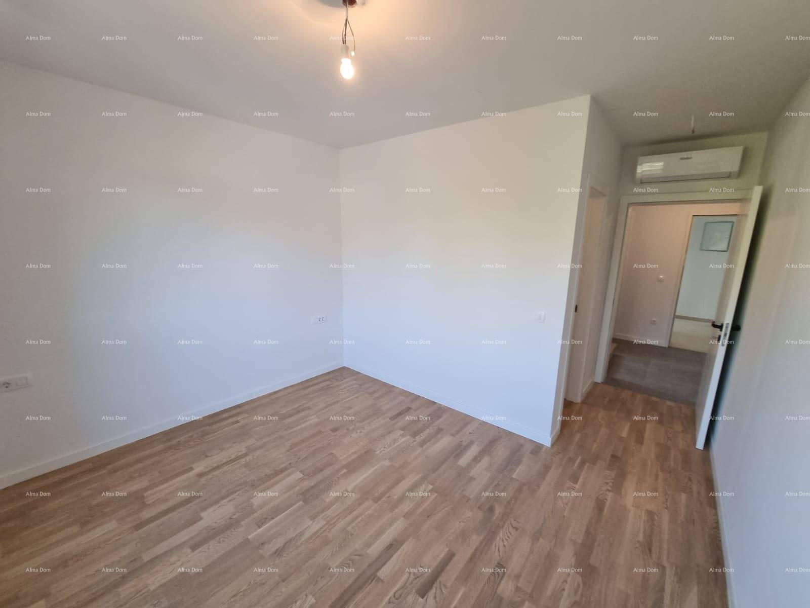 Helles Schlafzimmer mit Holzparkett und Klimaanlage, bereit für die individuelle Einrichtung.