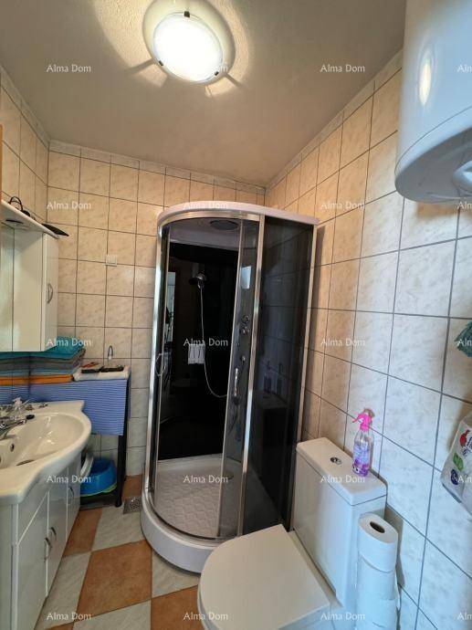 Kleines Badezimmer mit Duschkabine, WC und Waschbecken, ausgestattet mit hellen Fliesen.