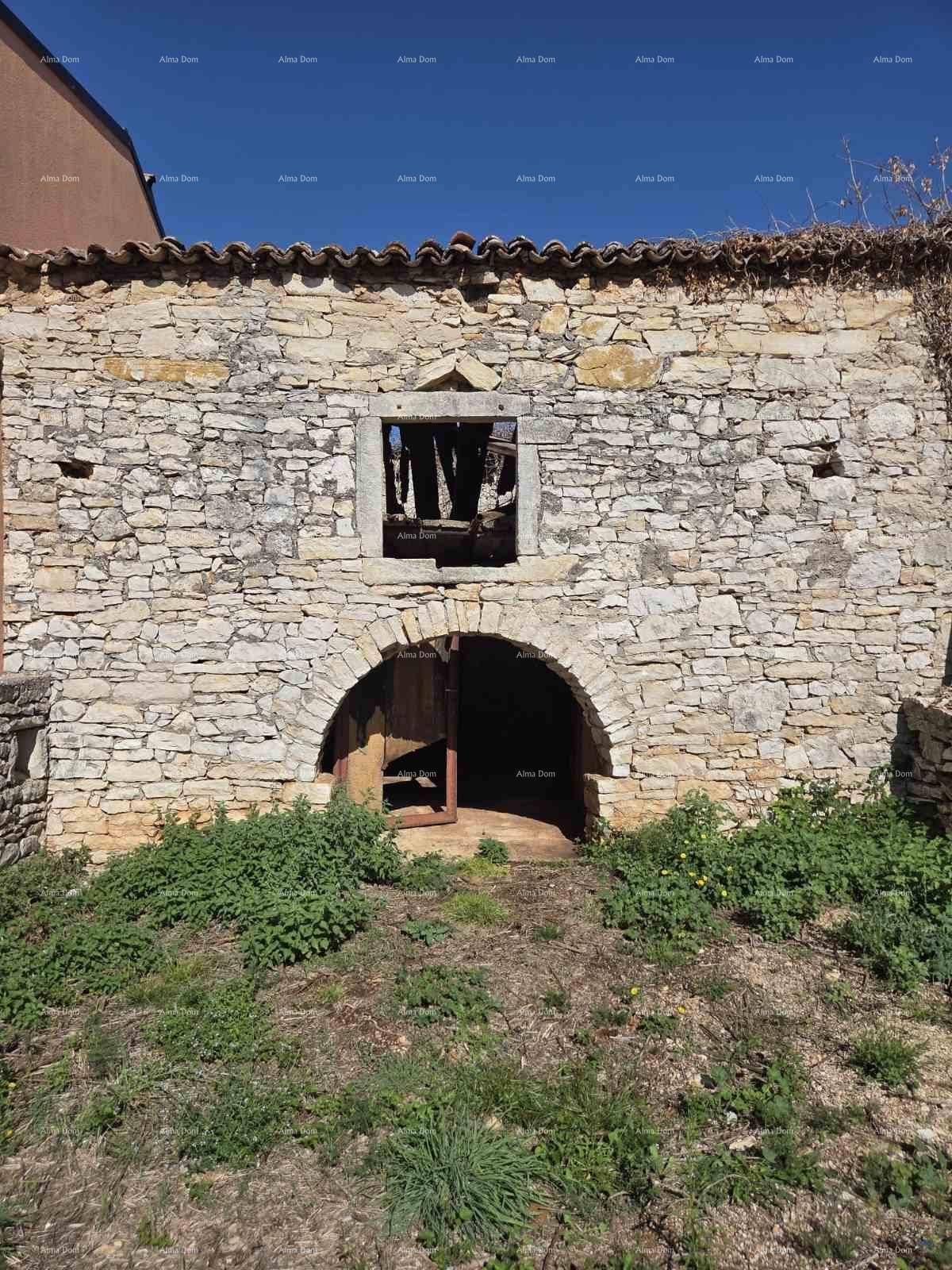Gesamtansicht des alten Steingebäudes mit bogenförmigem Eingang, Fensteröffnung und Ziegeldach.