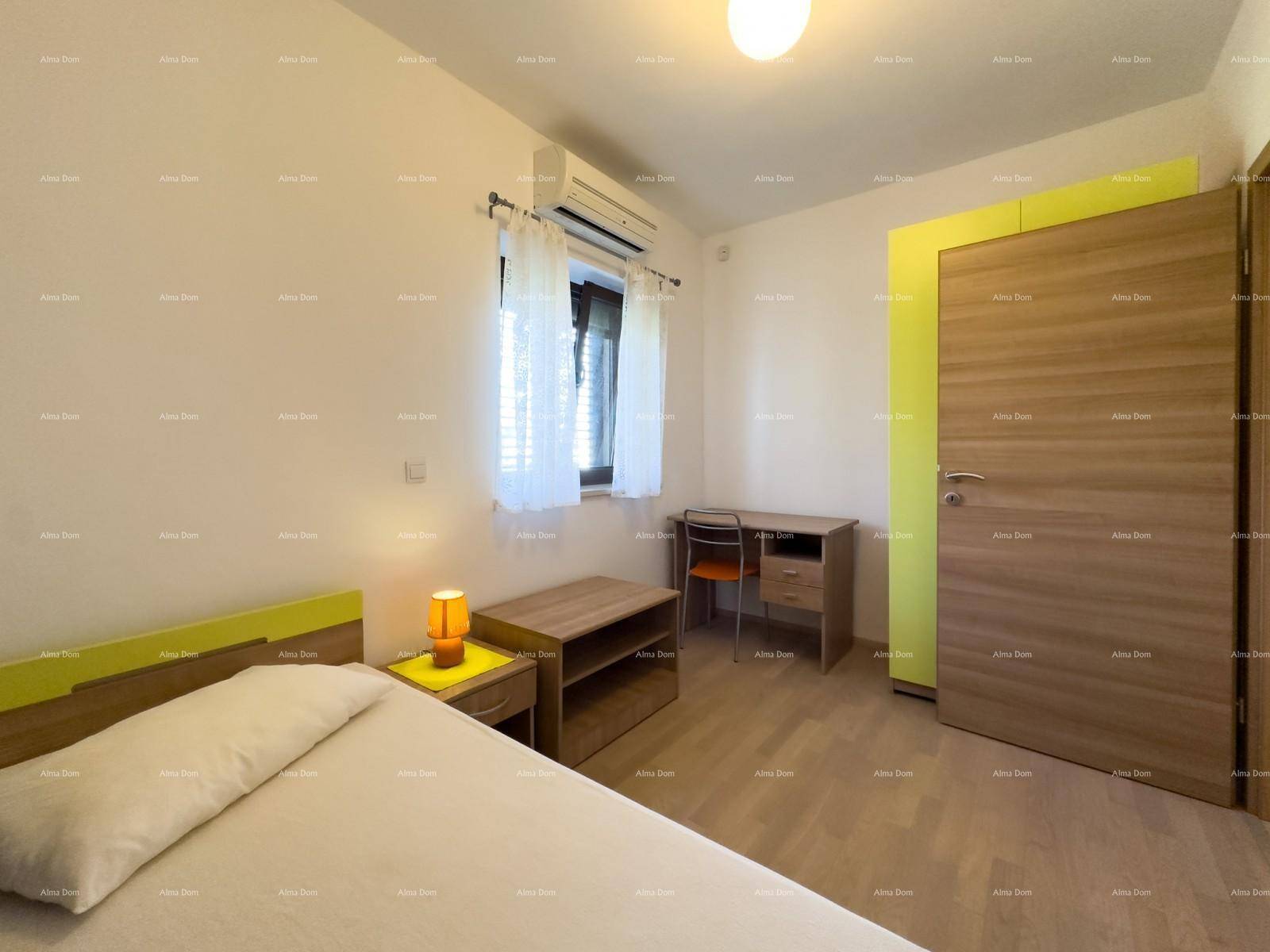 Schlafzimmer mit Einzelbett, Schreibtisch und einem gelben Kleiderschrank.
