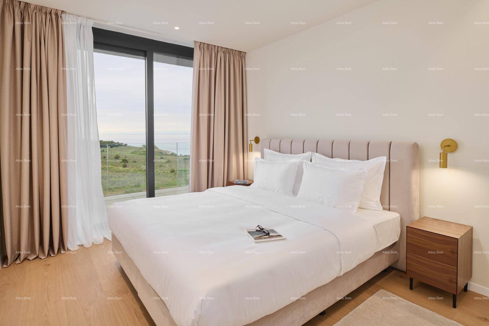 Helles Schlafzimmer mit großem Bett, Holzboden und Meerblick durch bodentiefe Fenster.