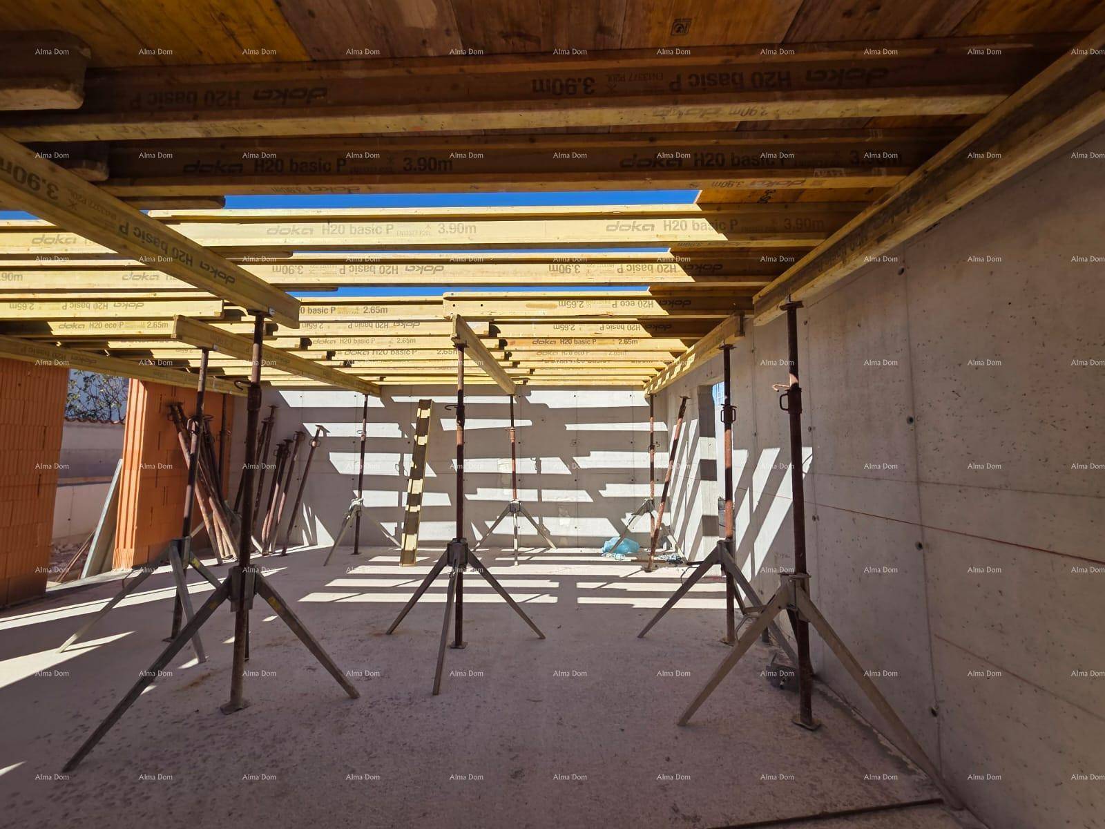 Baustelle eines im Bau befindlichen Hauses mit Betonwänden und Holzschalung.