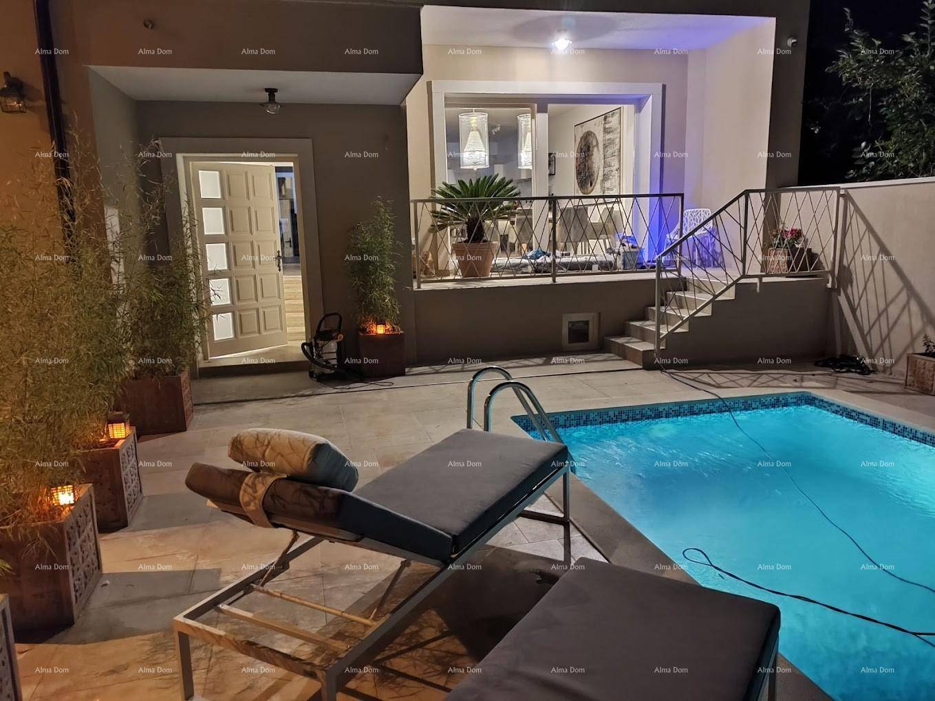 Beleuchteter Poolbereich bei Nacht mit Liegestühlen und Zugang zum Haus.