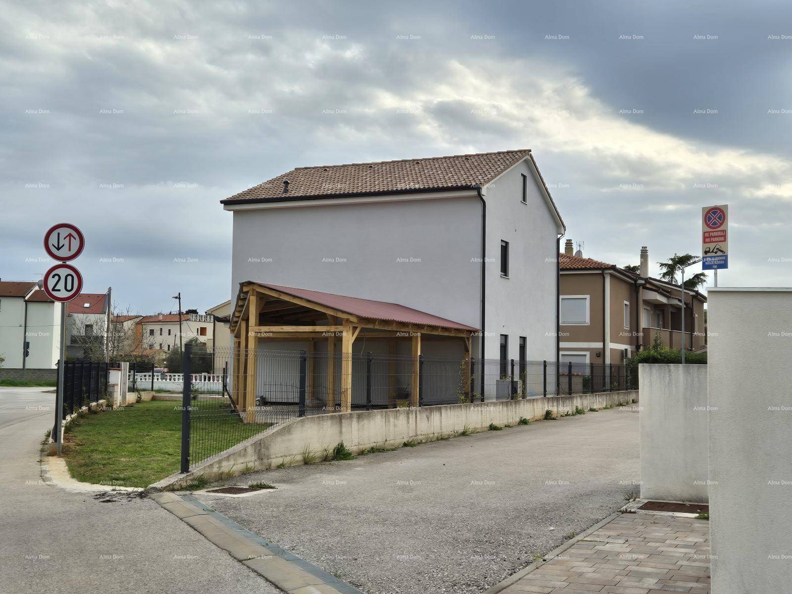 Rückansicht des Wohnhauses mit Holz-Carport und angrenzender Straße unter bewölktem Himmel.