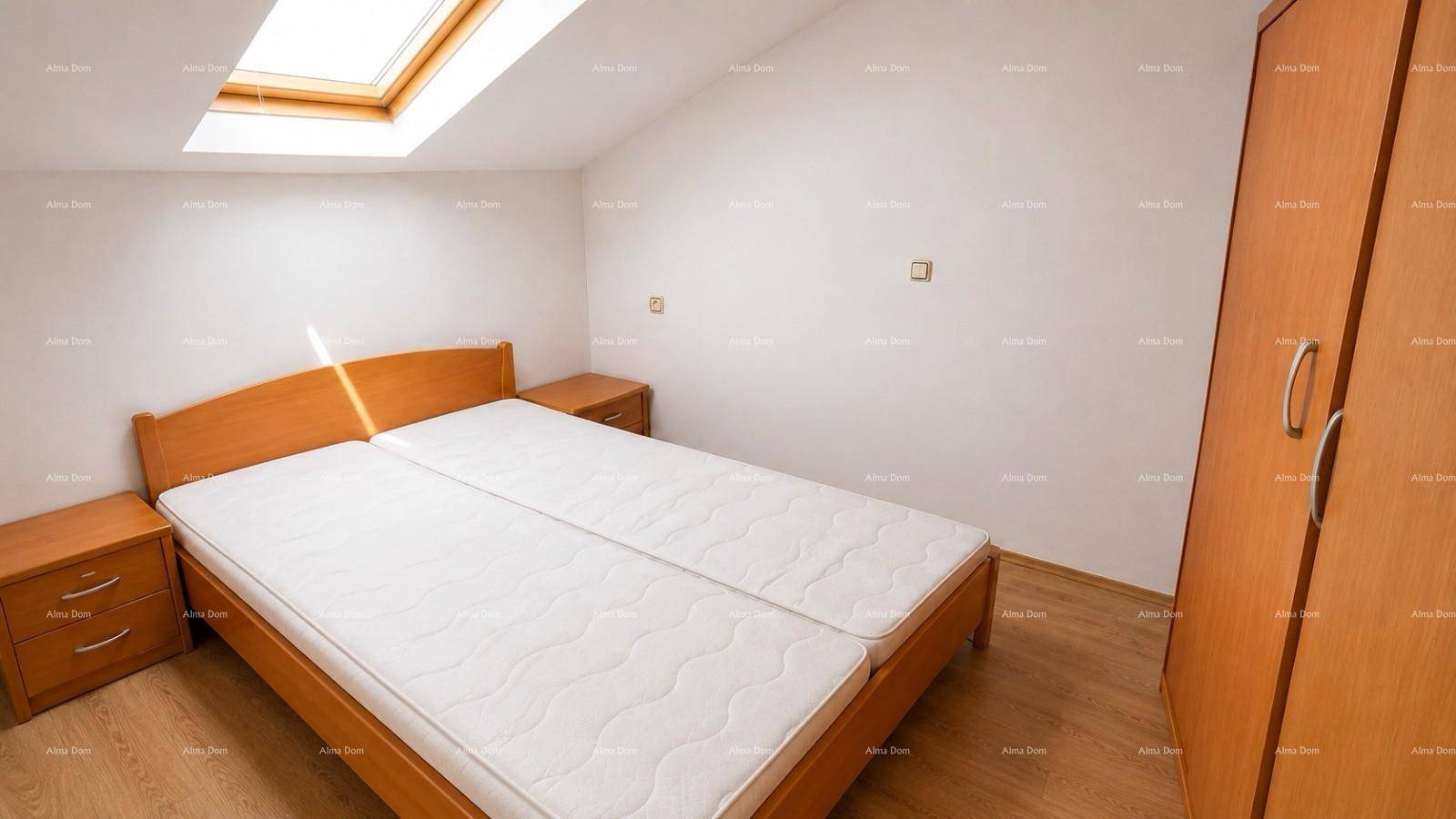 Gemütliches Schlafzimmer im Dachgeschoss mit Doppelbett, Holzschrank und Dachfenster.