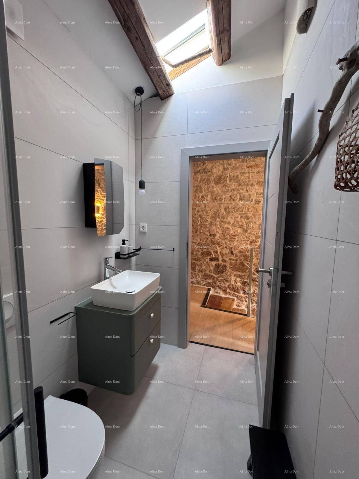 Modernes Badezimmer mit Waschbecken, WC und Dachfenster für natürliches Licht.