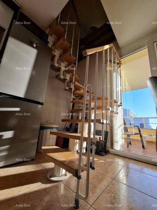 Detailansicht der Wendeltreppe und des Kühlschranks im offenen Küchenbereich.