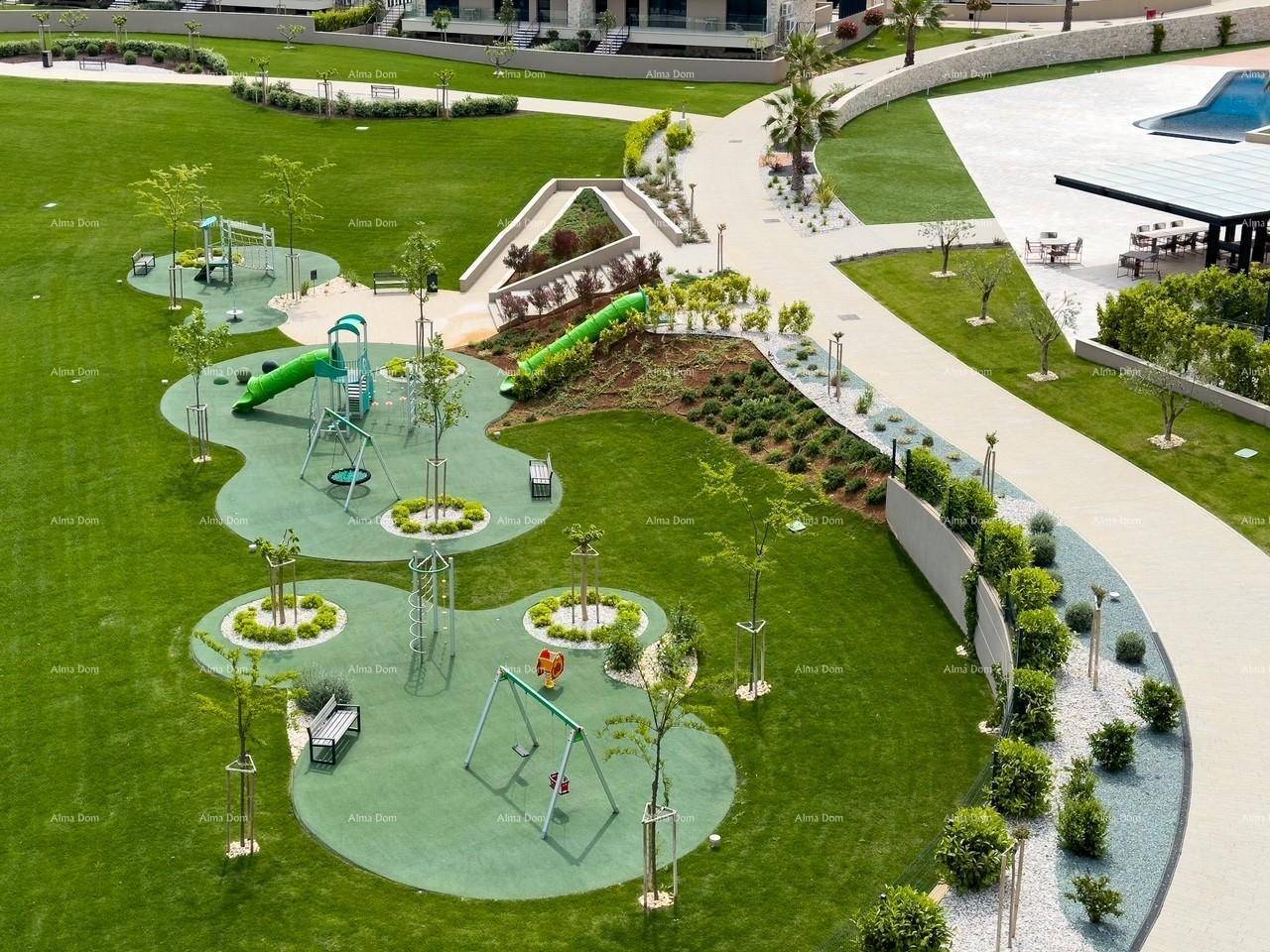 Weitläufige Grünanlage mit modernem Spielplatz, Rutschen und Schaukeln für Kinder.