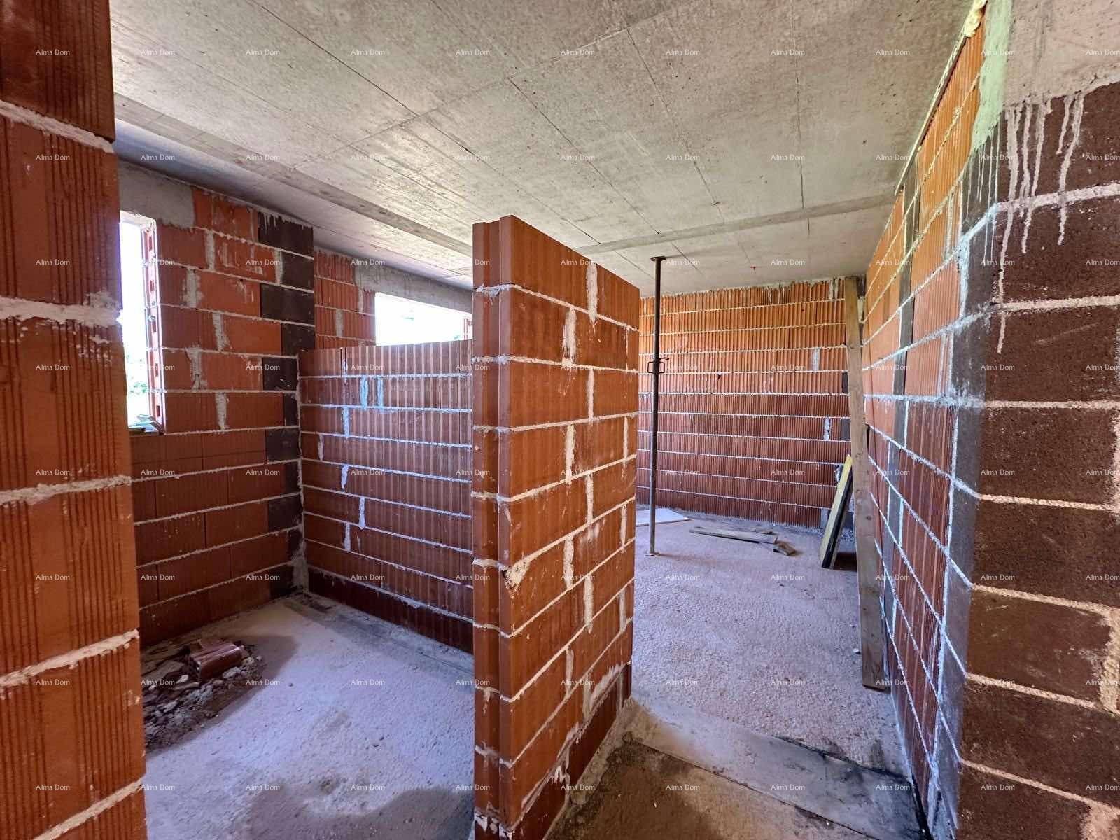 Rohbau eines Raumes mit Ziegelwänden, Betonflächen und einer Fensteröffnung.