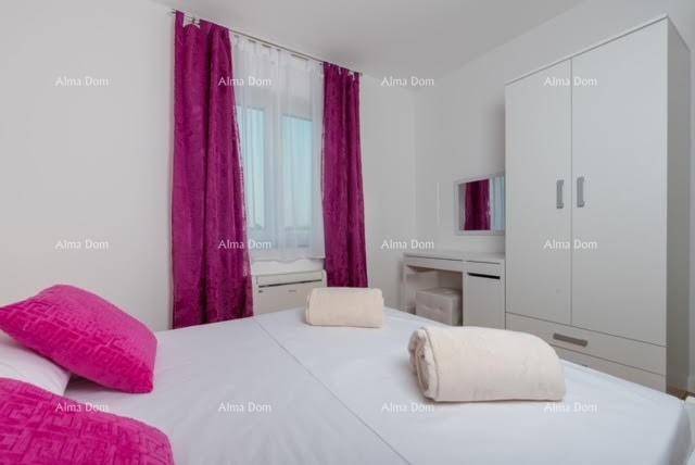 Schlafzimmer mit Doppelbett, weißem Kleiderschrank und einem Schminktisch am Fenster.