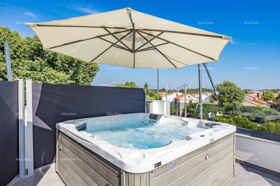 Großzügiger Whirlpool auf der Dachterrasse unter einem Sonnenschirm mit Weitblick.