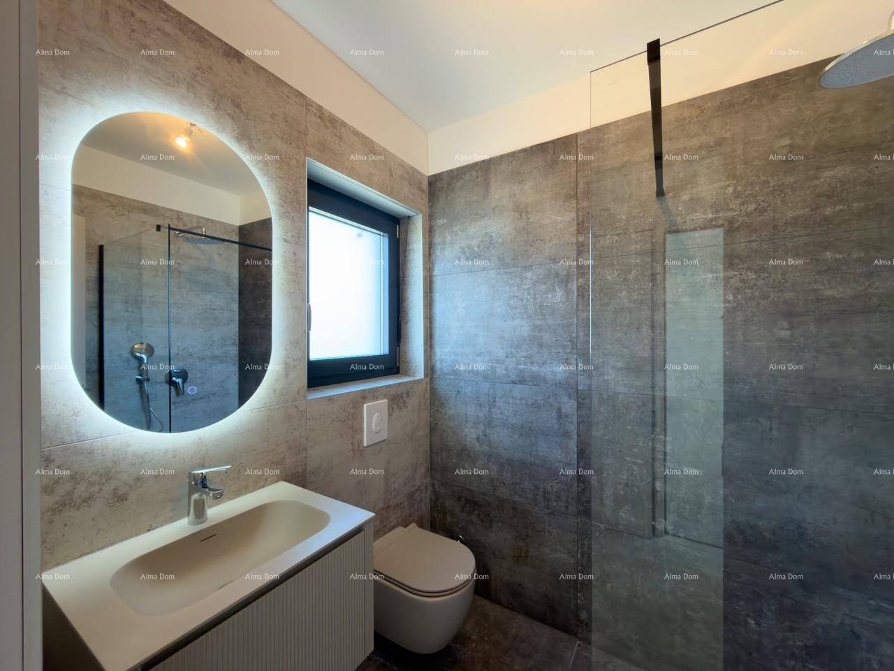 Modernes Badezimmer mit großformatigen Fliesen, beleuchtetem Spiegel und ebenerdiger Dusche.