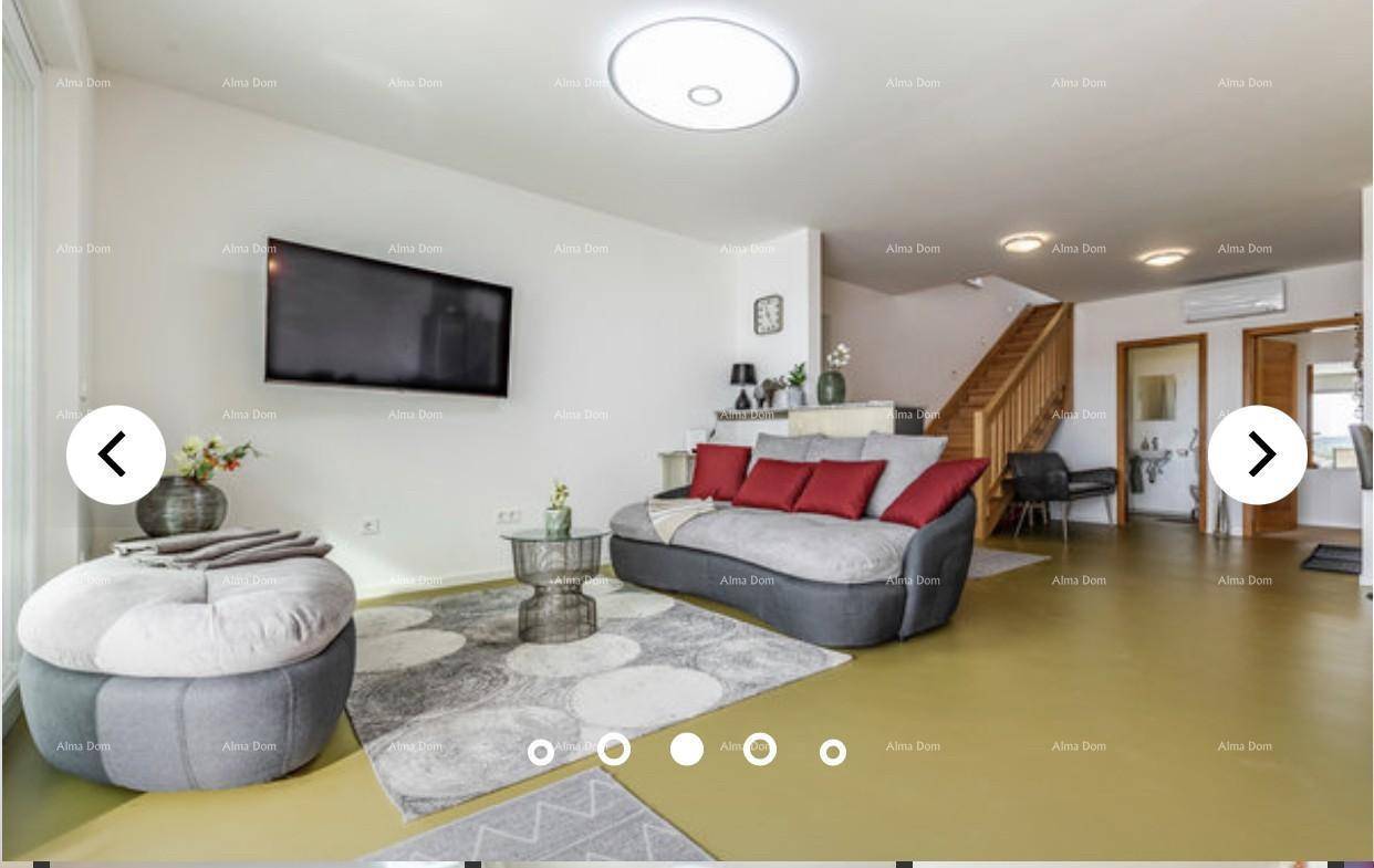 Gemütliches Wohnzimmer mit Sofa, Fernseher und Zugang zu den oberen Etagen.