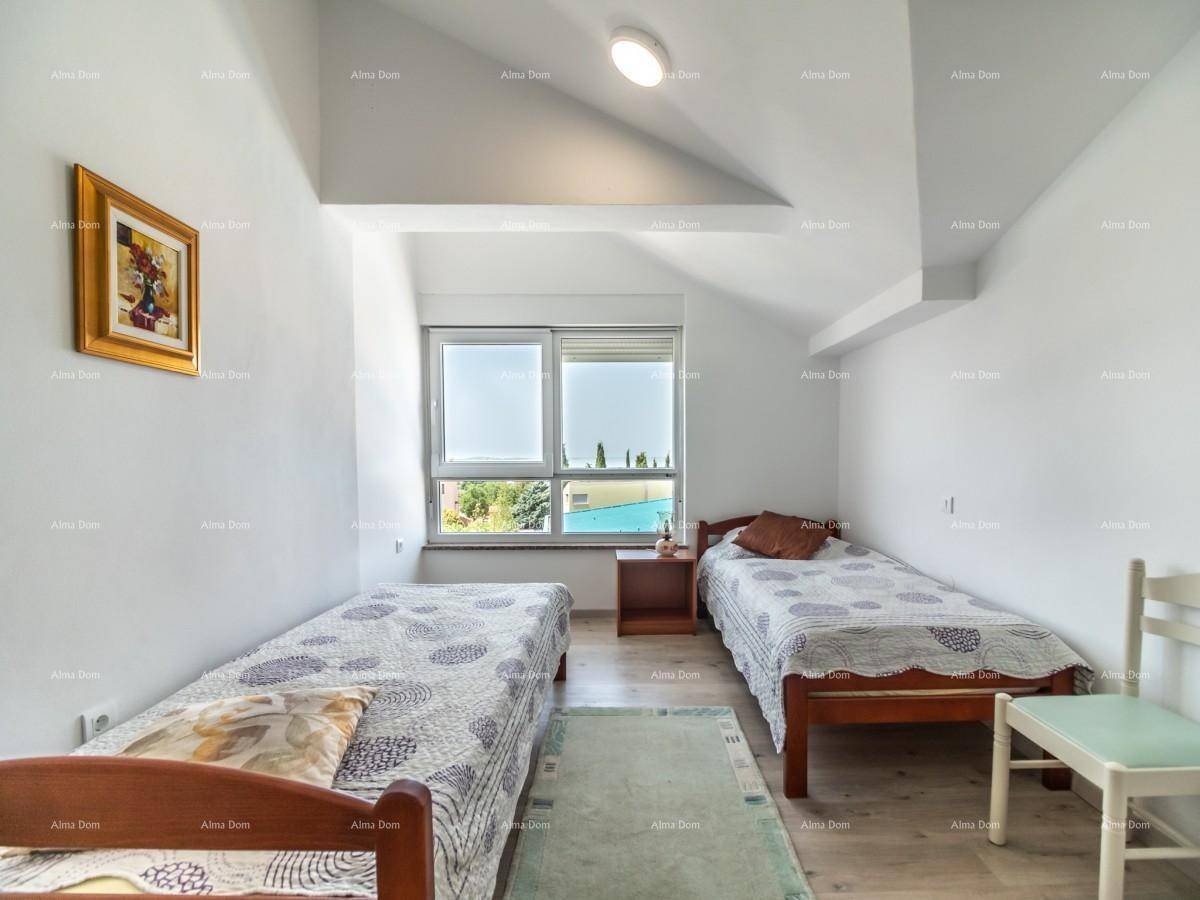 Helles Schlafzimmer mit zwei Einzelbetten, Dachschrägen und einem Fenster mit Ausblick.