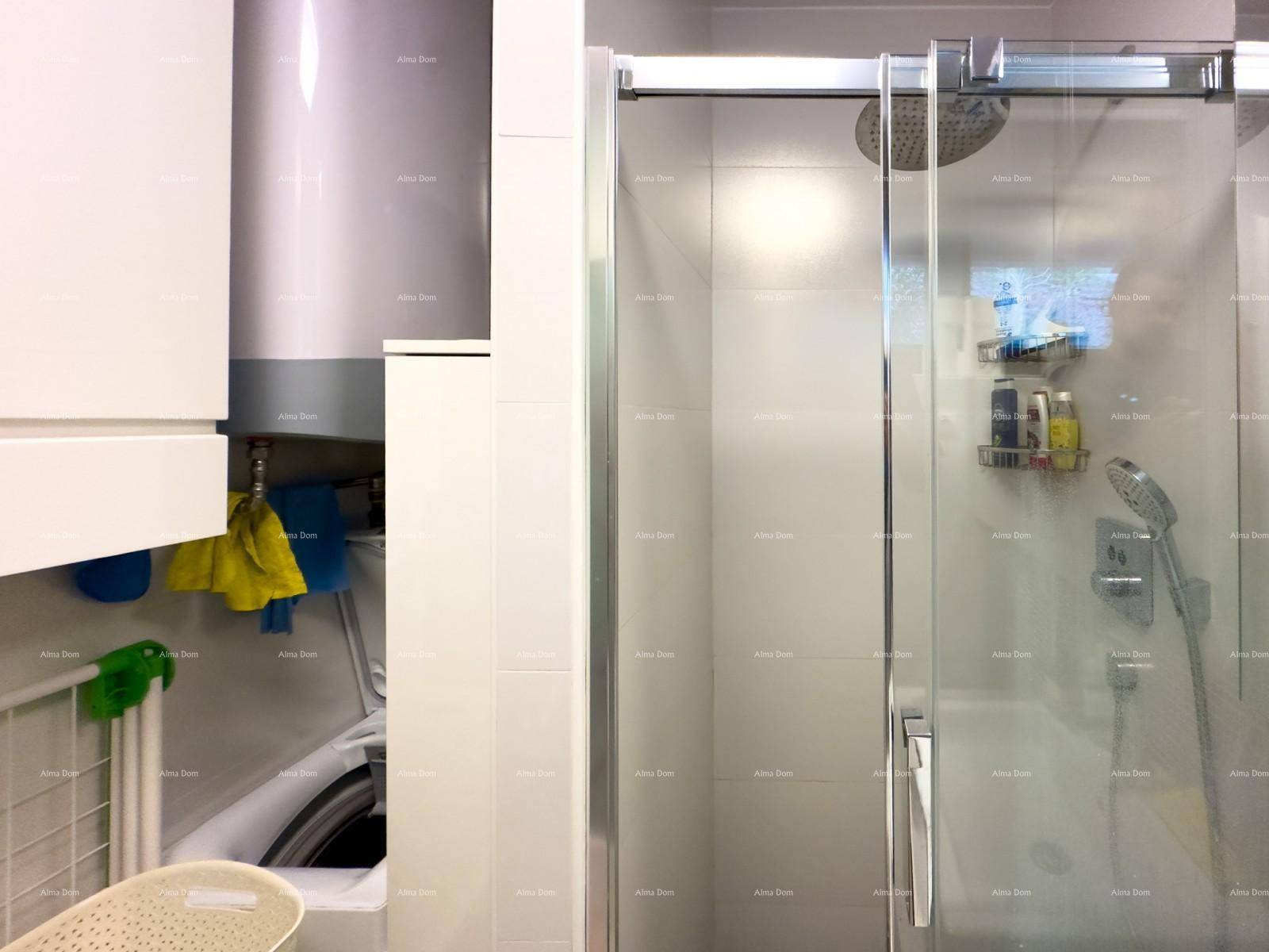 Praktischer Hauswirtschaftsbereich mit Warmwasserbereiter und Waschmaschine neben der Dusche.