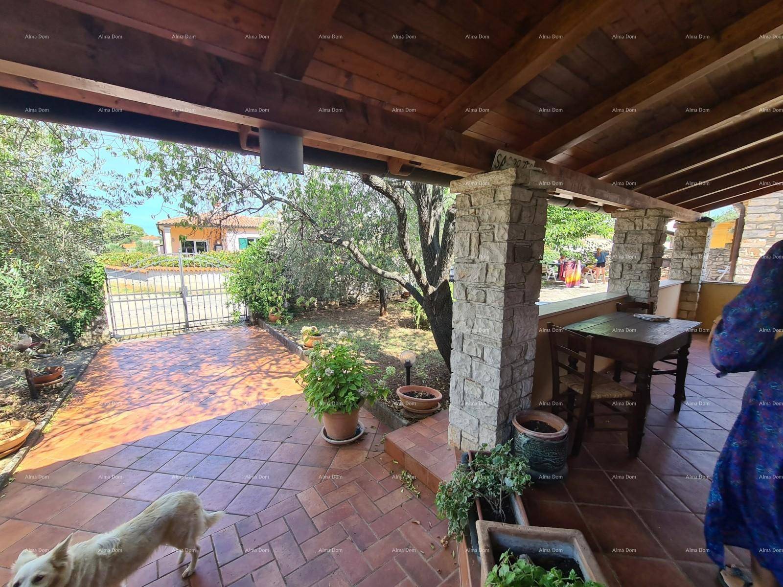 Überdachte Loggia mit Holzbalkendecke, Steinsäulen und Terrakotta-Boden, ideal für Mahlzeiten im Freien.