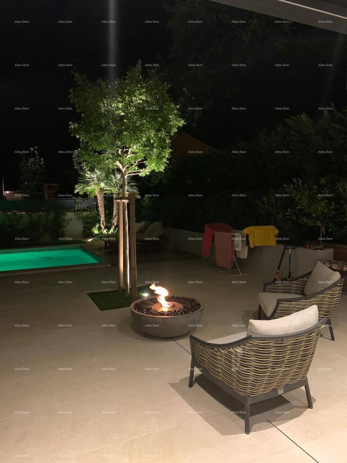 Gemütlicher Sitzbereich auf der Terrasse bei Nacht mit einem beleuchteten Feuerkorb.