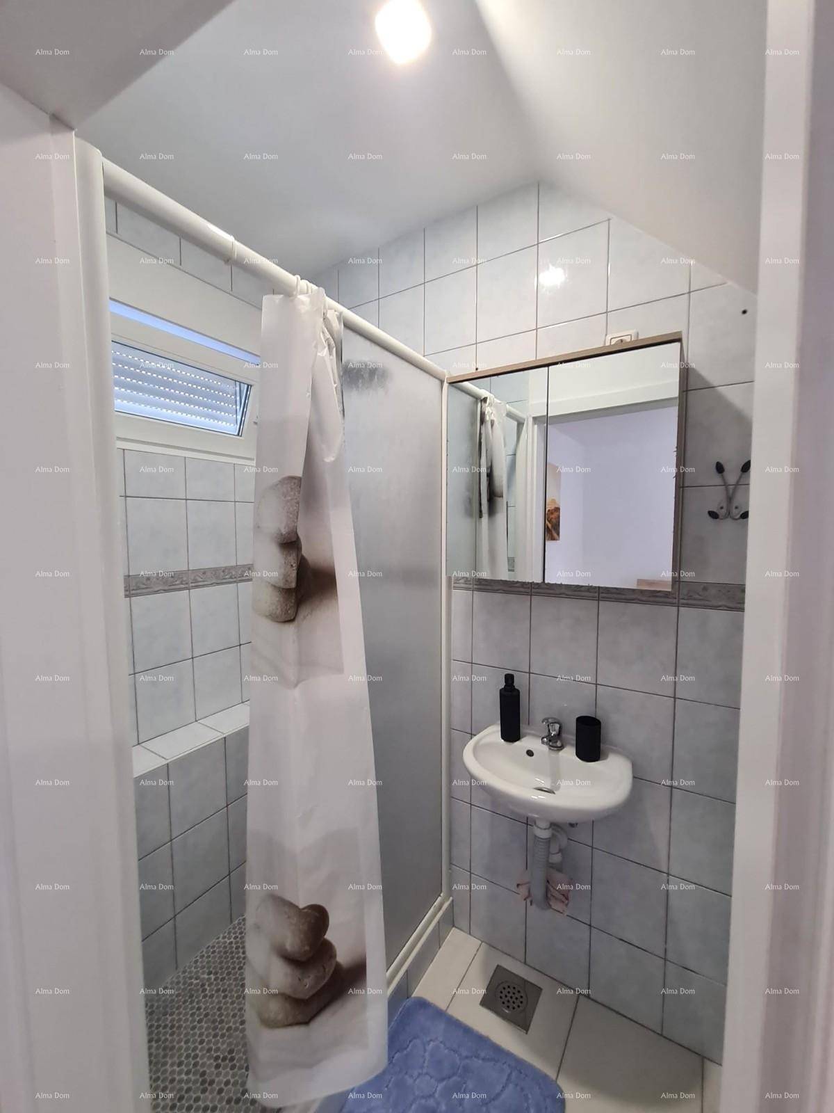 Badezimmer mit Duschkabine, Waschbecken und Spiegel, gefliest in hellen Tönen.