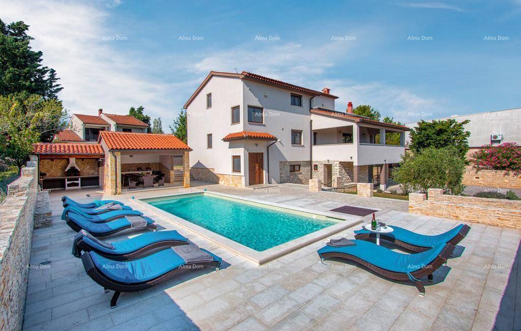 Weitläufiger Poolbereich mit Liegestühlen und Blick auf das moderne Wohnhaus.
