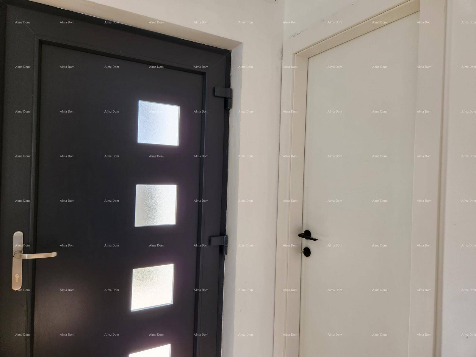 Zwei Türen in einem Innenraum, eine moderne schwarze Tür mit Glaseinsätzen und eine weiße Tür.