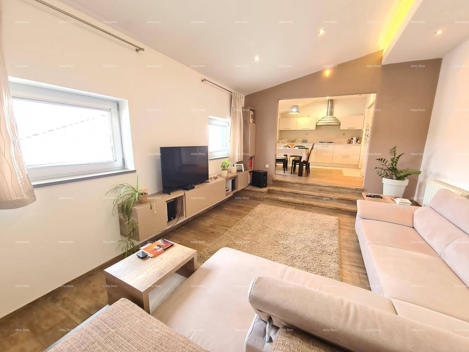 Heller Wohnbereich mit beigem Sofa und Blick auf die moderne Küche im Hintergrund.