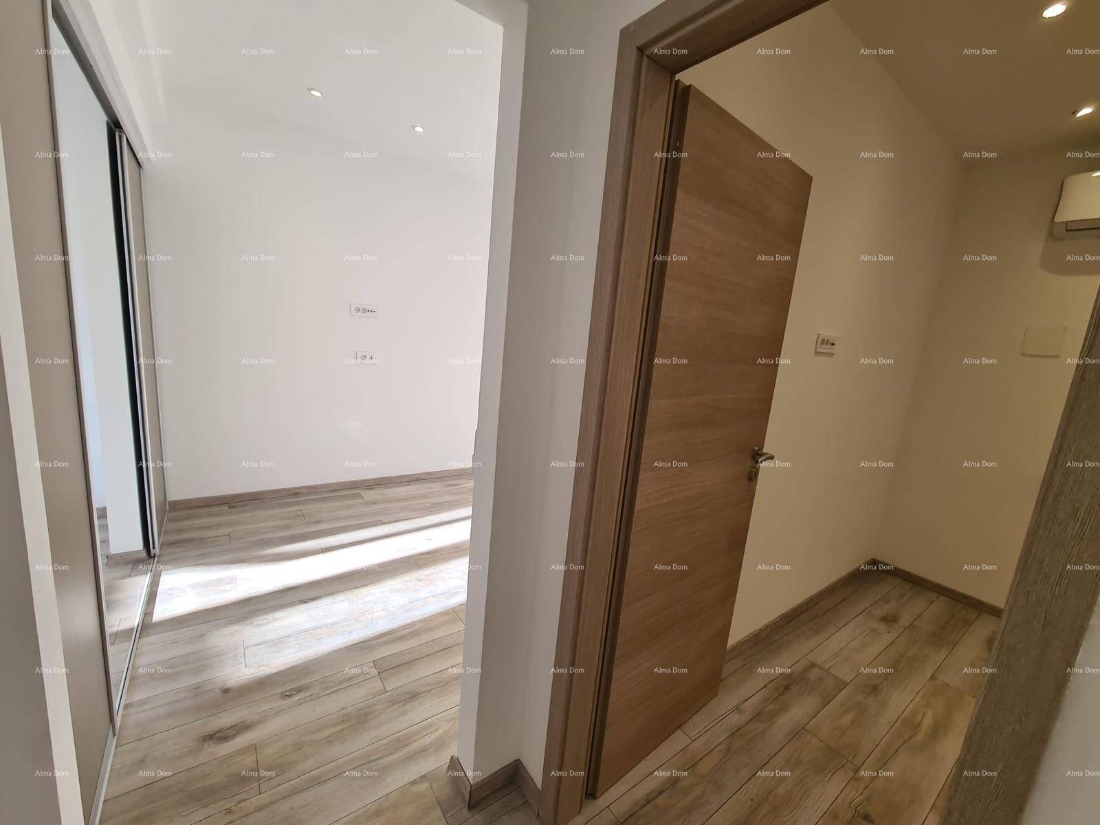 Flur mit Holzoptik-Fliesenboden und einer Holztür, die zu einem Zimmer führt.