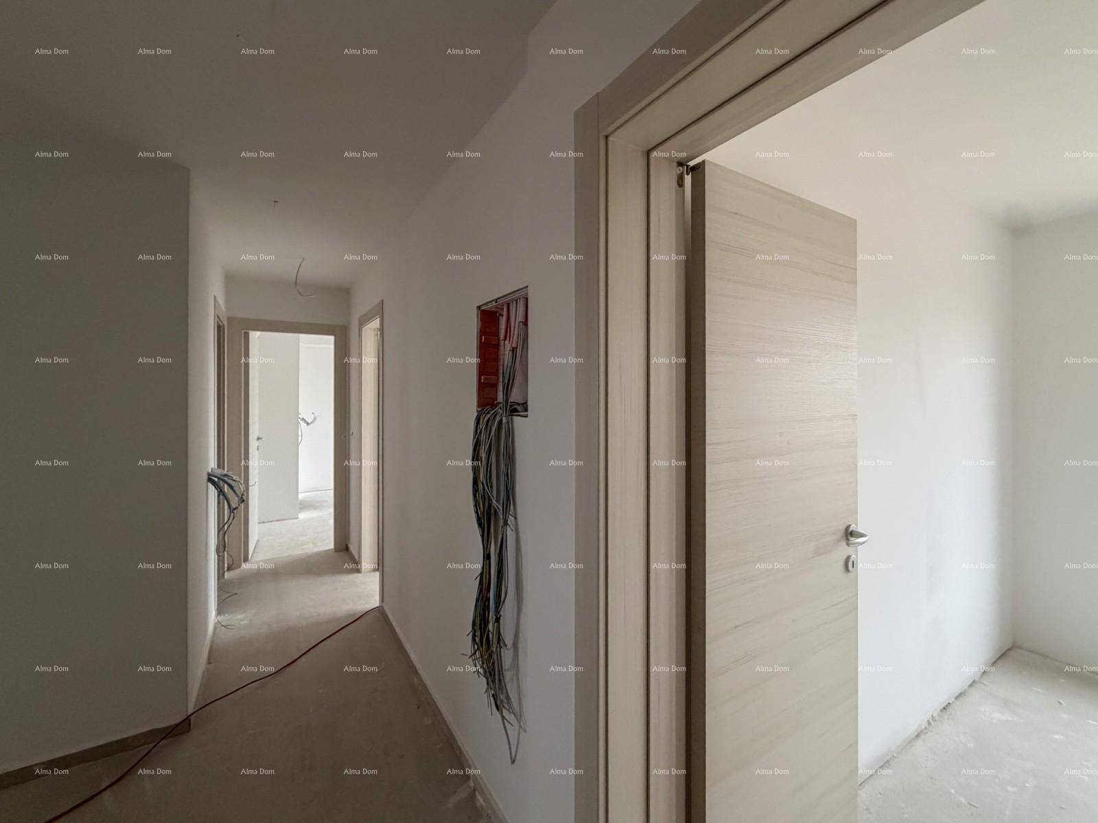 Langer Flur in einem Neubau mit unfertigen Wänden, Betonboden und mehreren Türen.