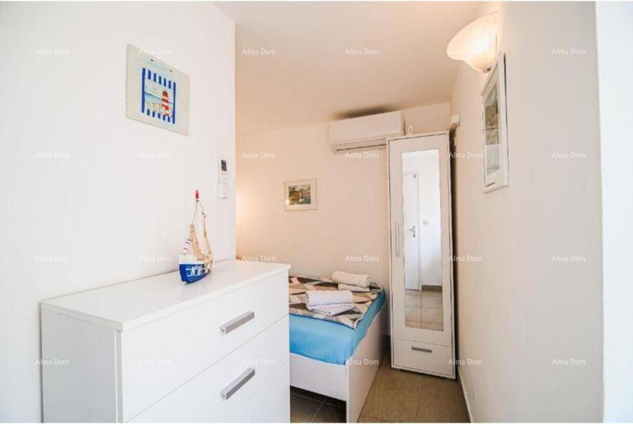 Helles Schlafzimmer mit Einzelbett, Kommode und Spiegelschrank, inklusive Klimaanlage.