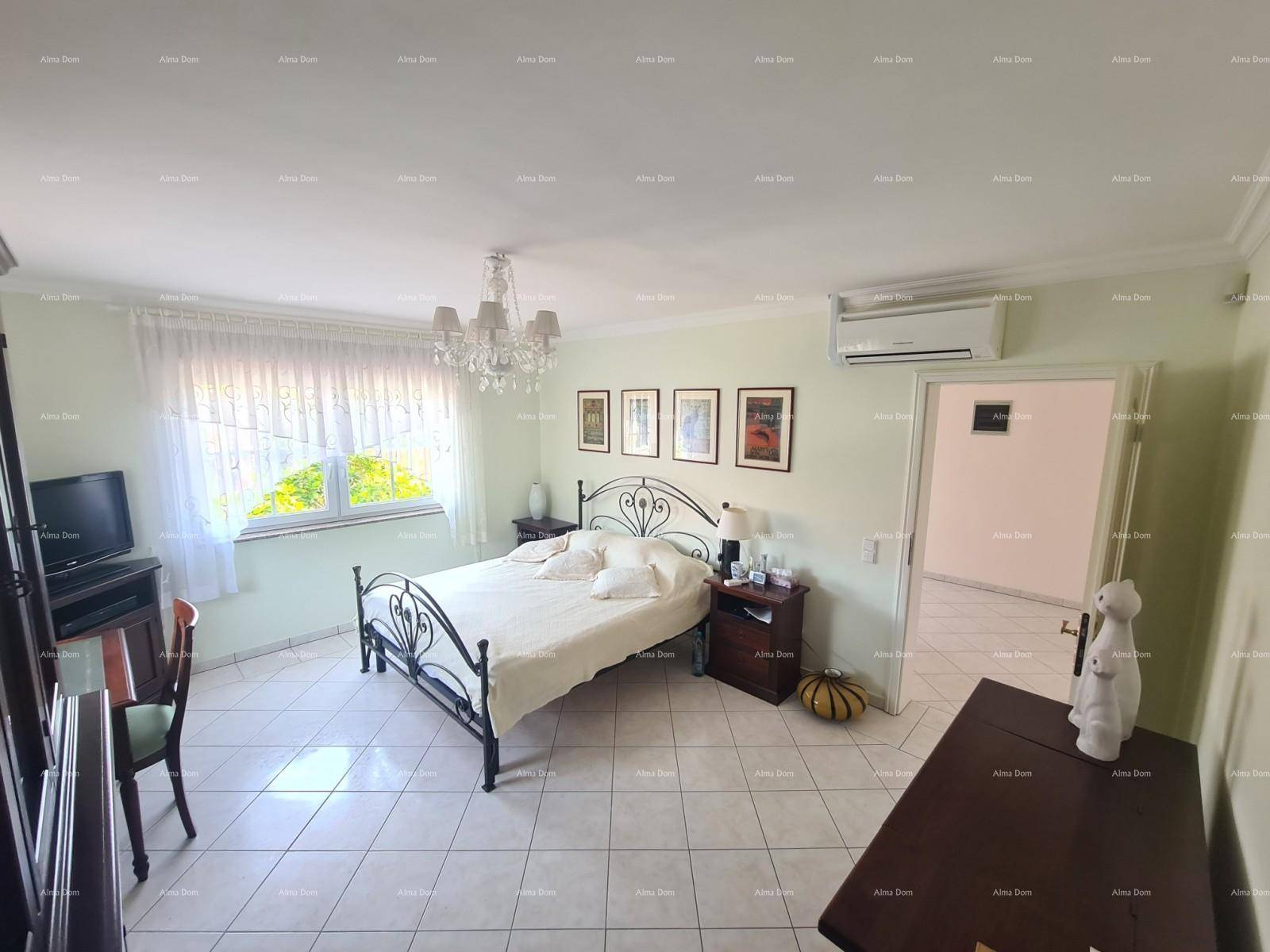 Geräumiges Schlafzimmer mit schmiedeeisernem Bett und Blick ins Grüne.