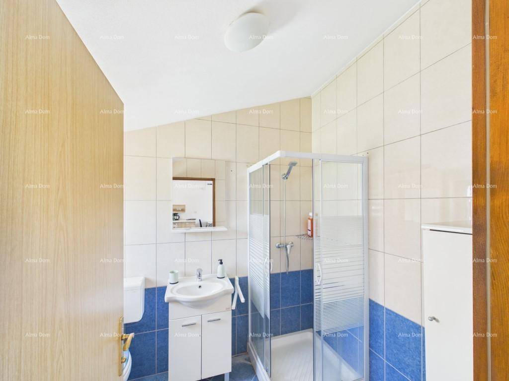 Modernes Badezimmer mit Duschkabine, WC, Waschbecken und einer Kombination aus blauen und weißen Fliesen.
