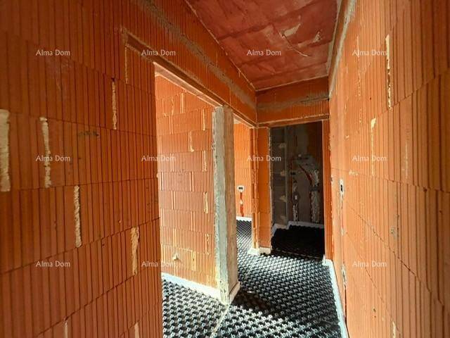 Unfertiger Flur mit Ziegelwänden und Fußbodenheizungsvorbereitung, bereit für den Ausbau.