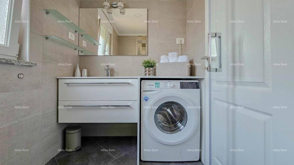 Modernes Badezimmer mit Waschbecken, Spiegel und integrierter Waschmaschine.