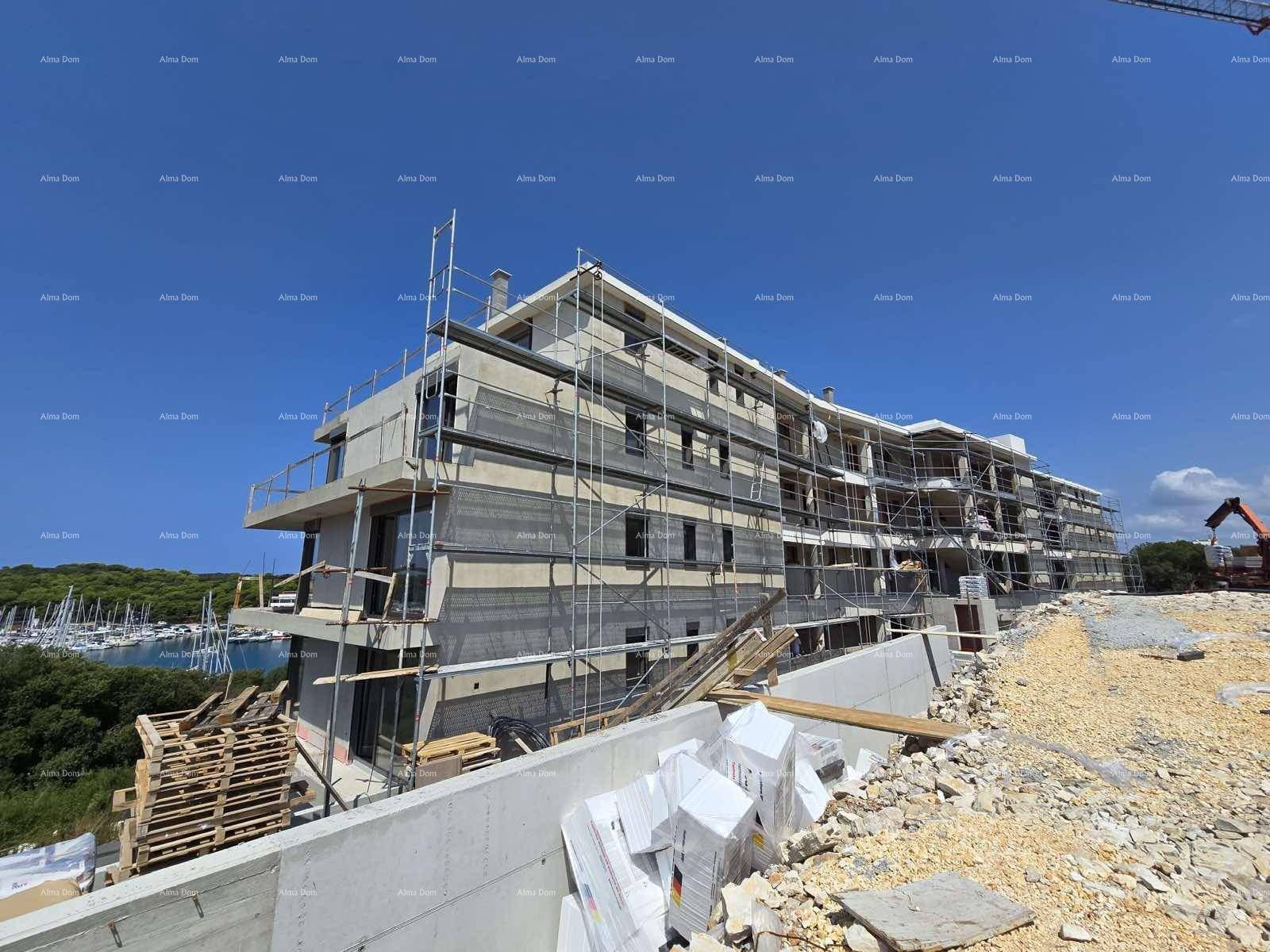 Neubau im Rohbau mit Gerüst und Blick auf das Meer und den Yachthafen.