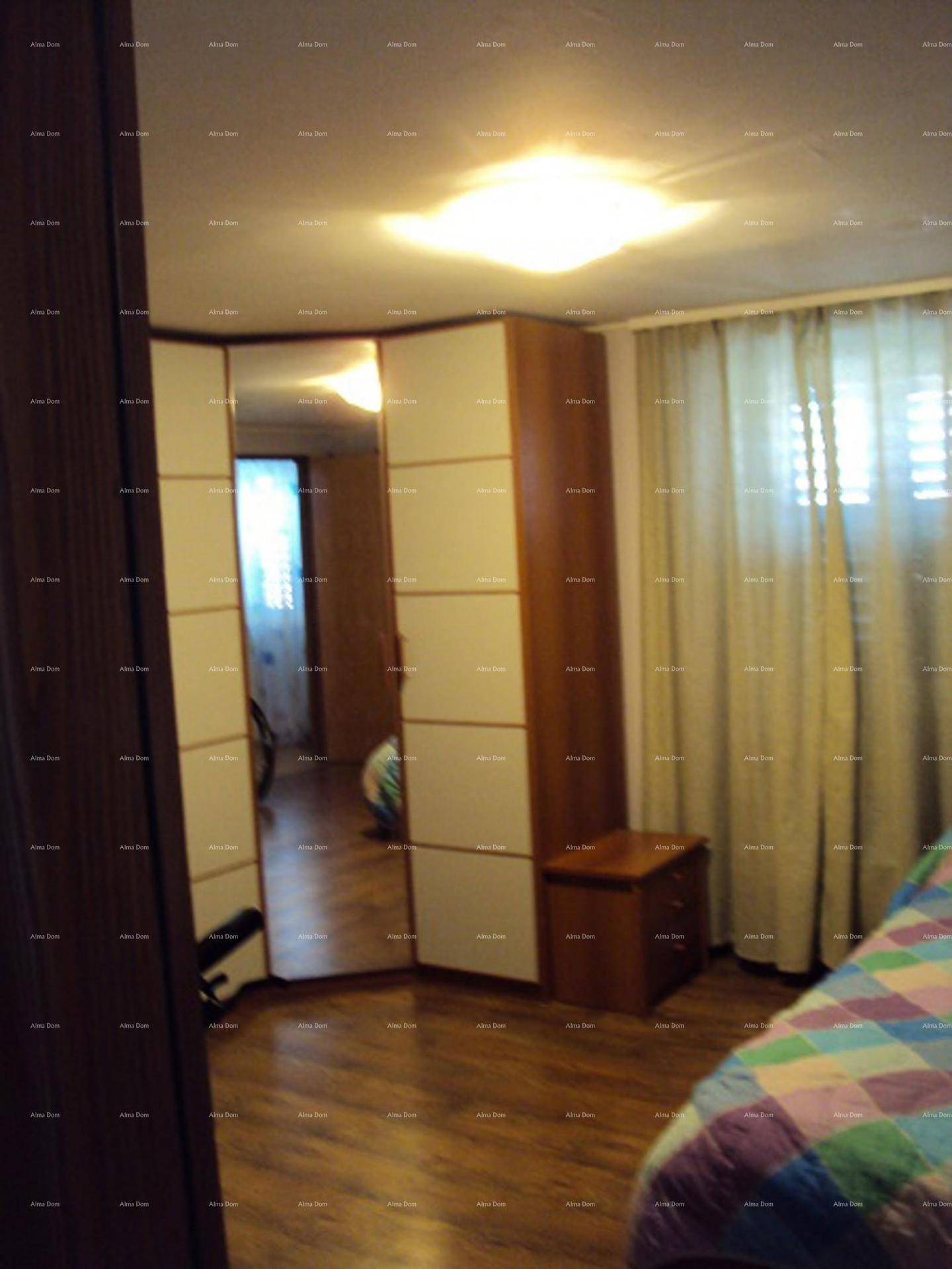 Schlafzimmer mit großem Kleiderschrank, Spiegeltür und Holzboden.