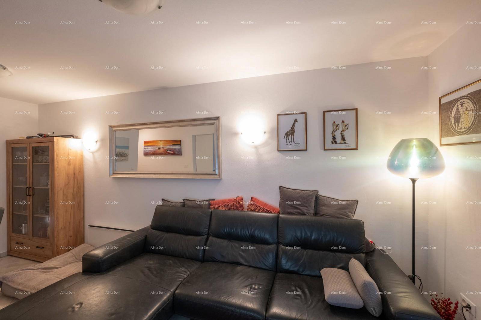 Detailansicht des Wohnzimmers mit großem Ledersofa, Spiegel und Stehlampe.