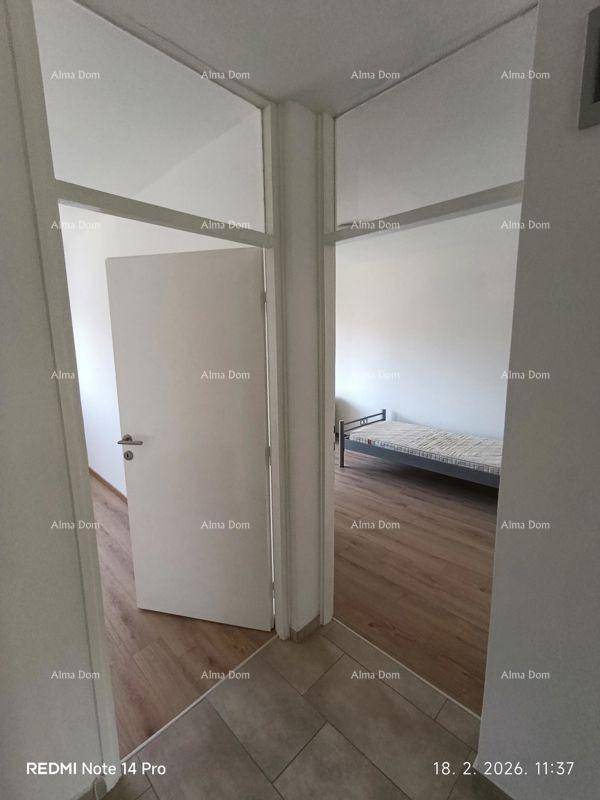 Heller Flur mit Übergang zu einem Schlafzimmer mit Holzfußboden.