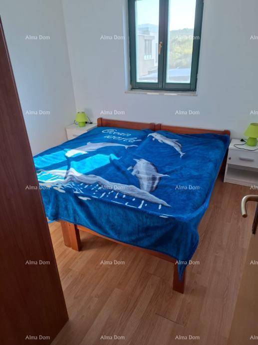 Schlafzimmer mit Doppelbett, Nachttischen und Fenster, das viel Tageslicht hereinlässt.