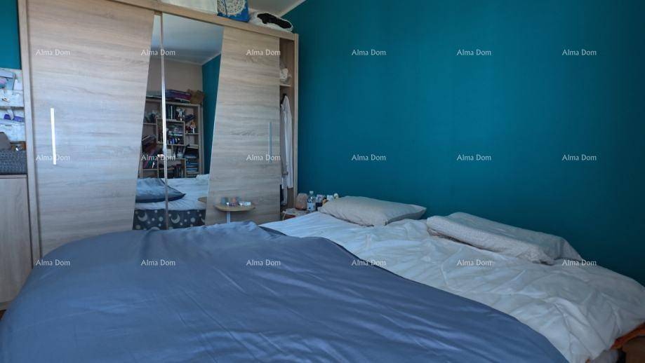 Schlafzimmer mit blaugrüner Wand, Doppelbett und großem Spiegelschrank.