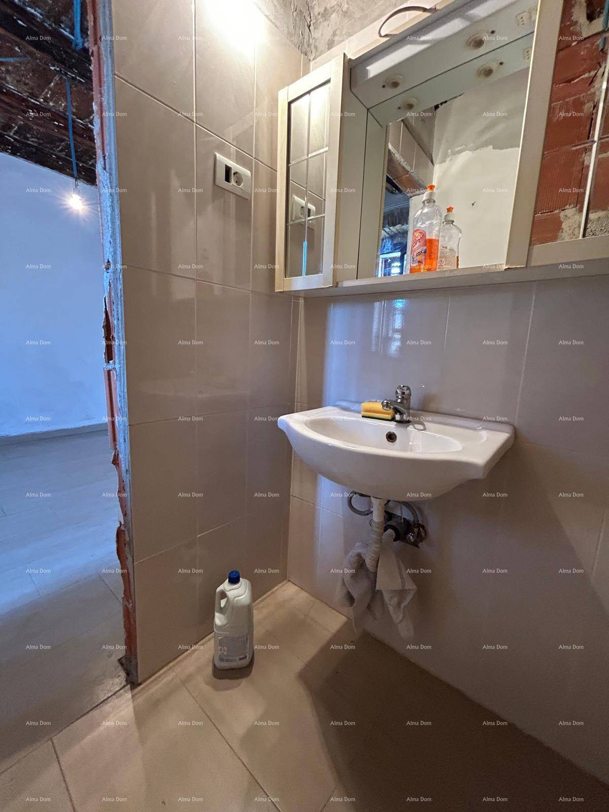 Badezimmer mit modernem Waschbecken, Spiegelschrank und hellen Wand- und Bodenfliesen.
