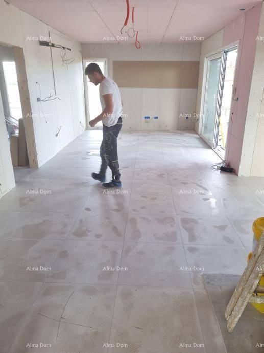 Innenraum im Bau mit frisch verlegten hellgrauen Bodenfliesen und viel Tageslicht.