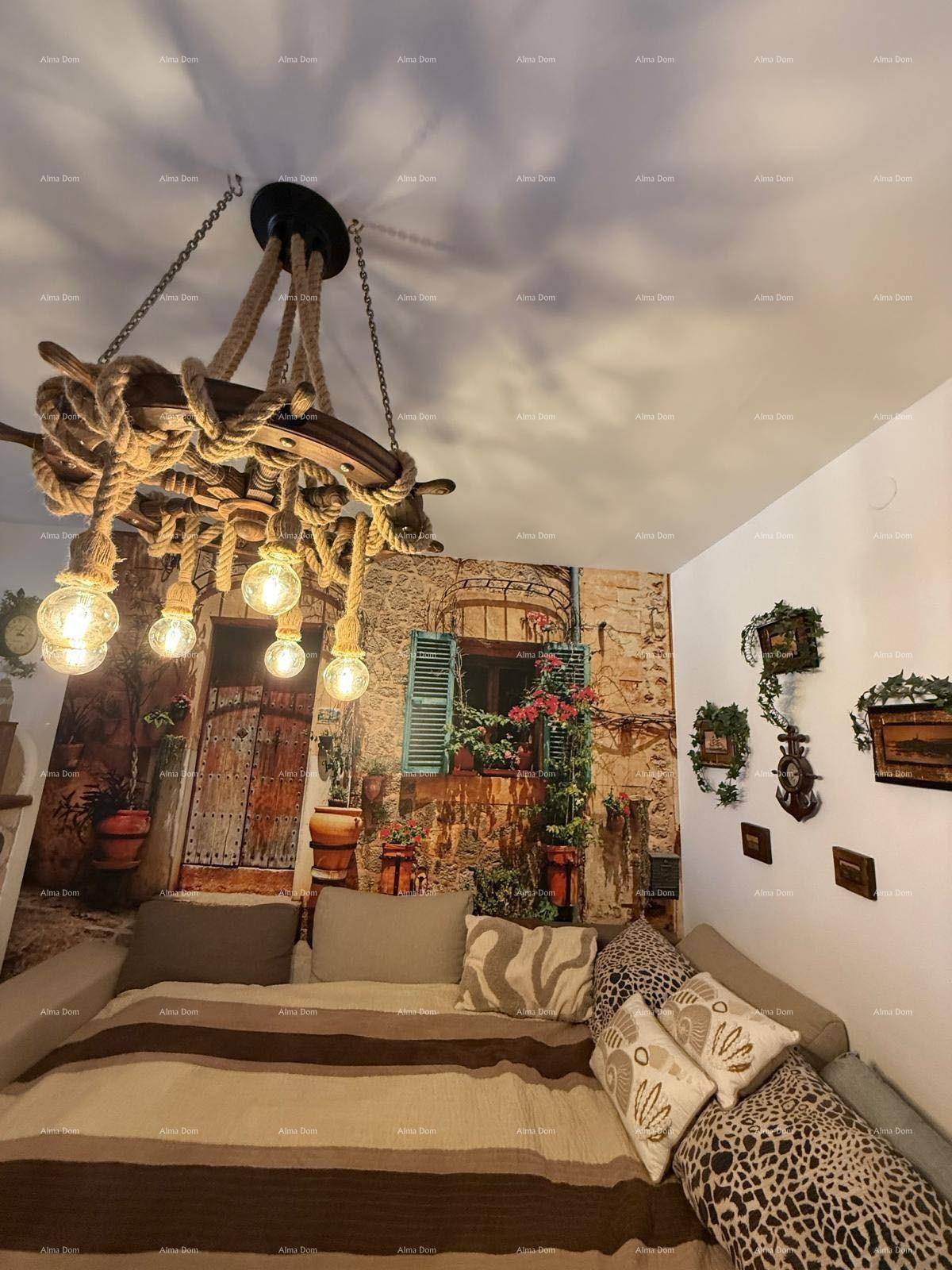Gemütliche Sofaecke mit rustikalem Seil-Kronleuchter und einer Wanddekoration im mediterranen Stil.