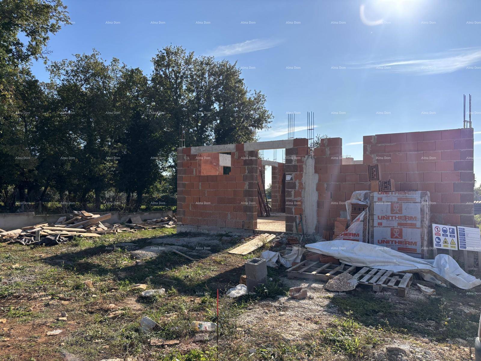 Baustelle eines Neubaus mit sichtbaren Ziegelwänden und Baumaterialien.